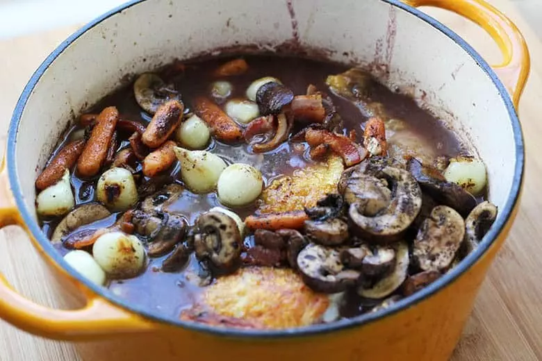 How to make Coq Au Vin, chicken with wine. An easy method similar to Beouf Bourguignon, this recipe layers on flavors and crates very few dirty dishes. A one pot meal!