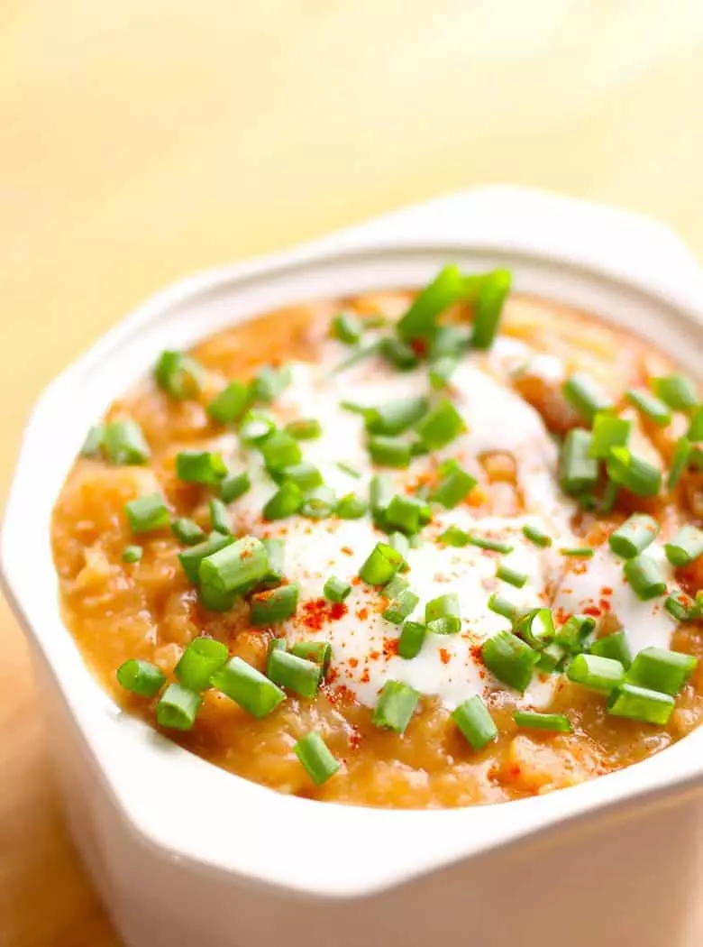 Mayocoba Bean Soup, a hearty Peruvian soup. This is also known as Canary Bean Soup with parsnips, onions, garlic and smoked paprika. Garnish with sour cream, scallions and smokey bacon.