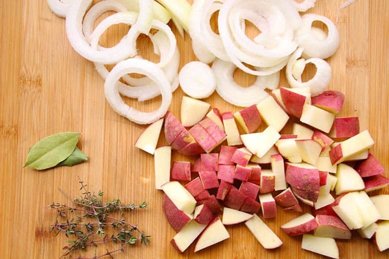 Chopped onions and potatoes, bay leaves and thyme leaves.