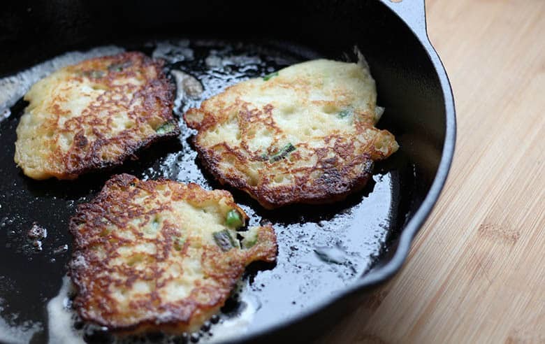 golden brown Boxty patties frying in a pan.