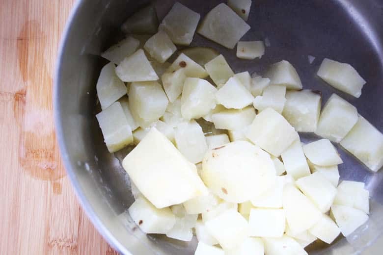 Potatoes and butter in a pan ready to mash.