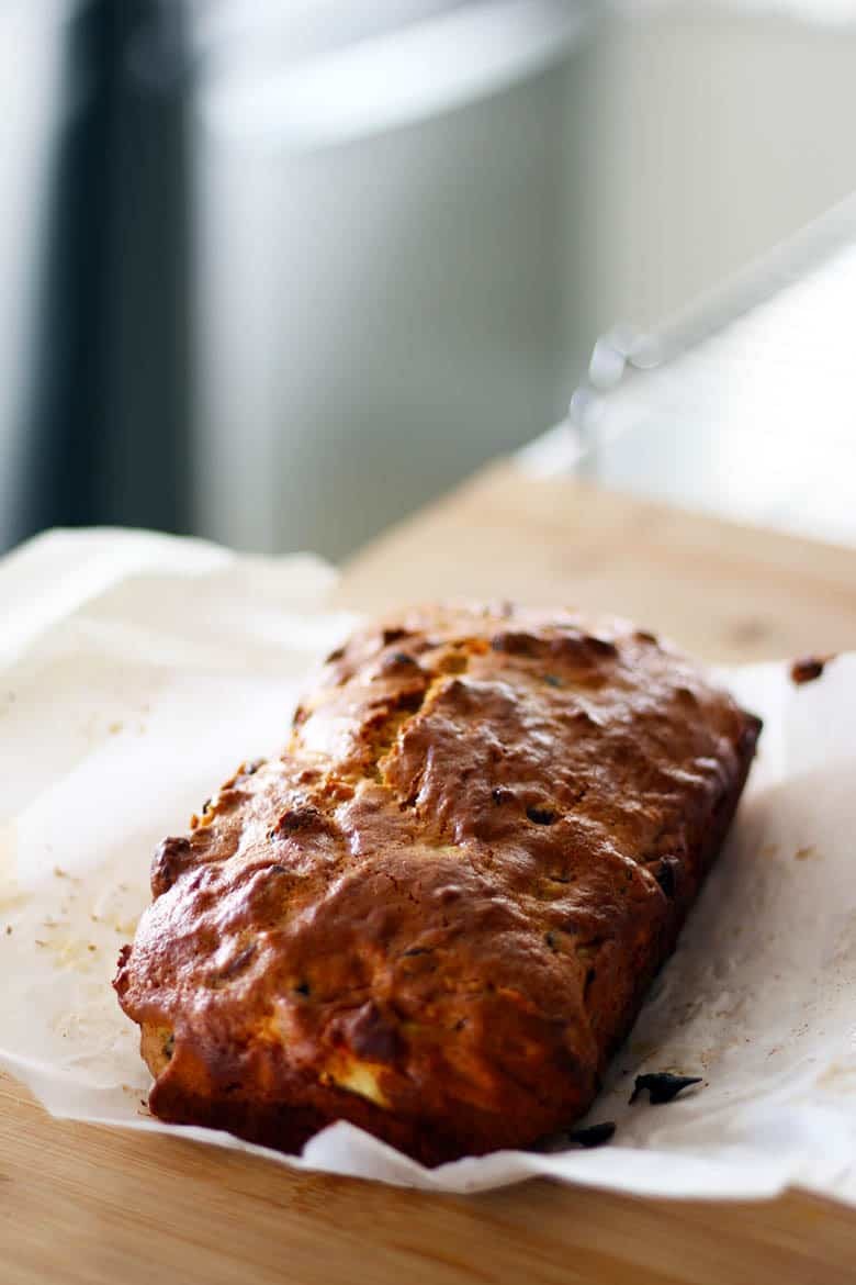 Golden brown apple and mince bread loaf on a cutting board.