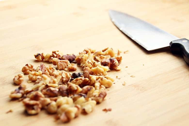 Chopped walnuts on a cutting board.