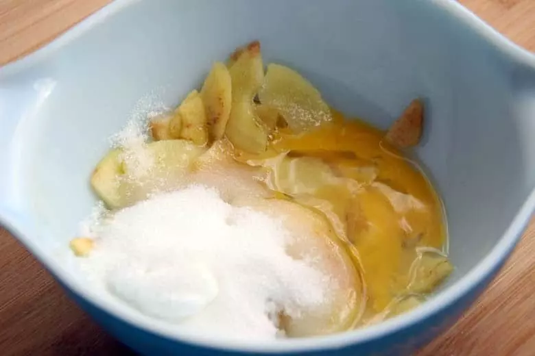 A bowl of apple slices with sugar.