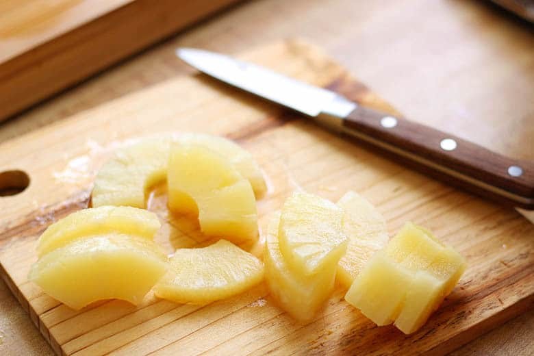 Pineapple sliced on a cutting board.