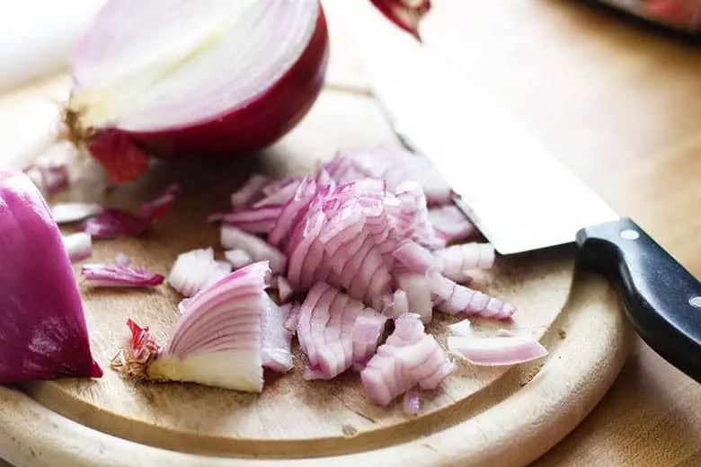 Diced red onion on a cutting board.