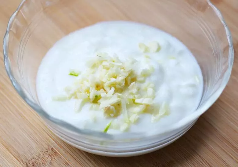 A bowl of plain yogurt with garlic.