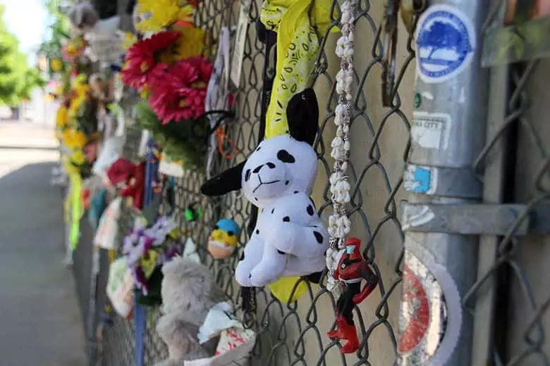 A stuffed animal on a chainlink fence.