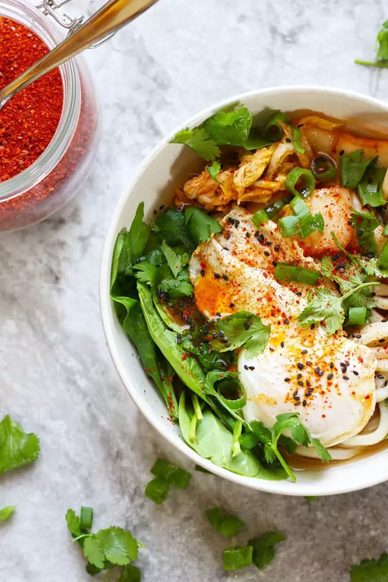 Kimchi Udon Noodle Soup, a quick and easy Korean meal. Udon noodles, kimchi, fried egg, spinach, sesame oil, fish sauce, chili oil, scallions, cilantro.