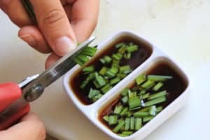 Mincing herbs with kitchen scissors.