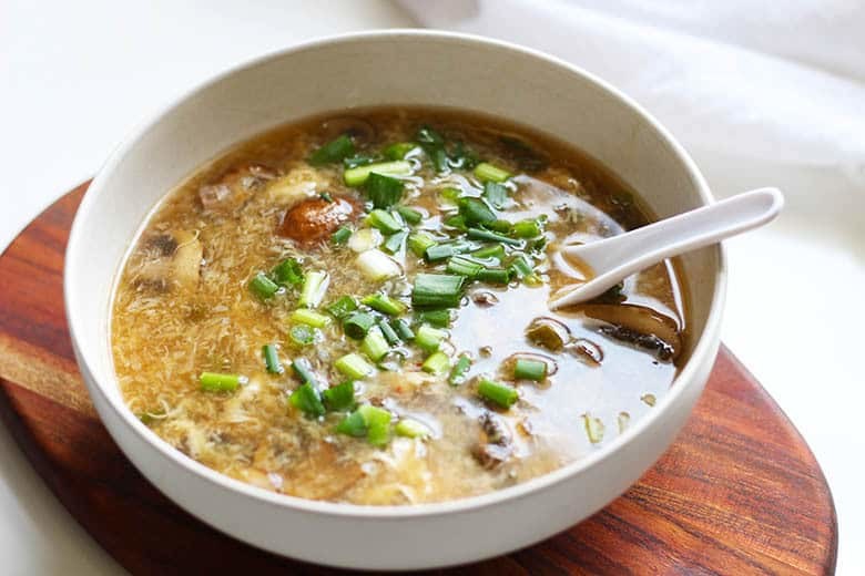 A bowl of Hot and Sour Soup with a soup spoon