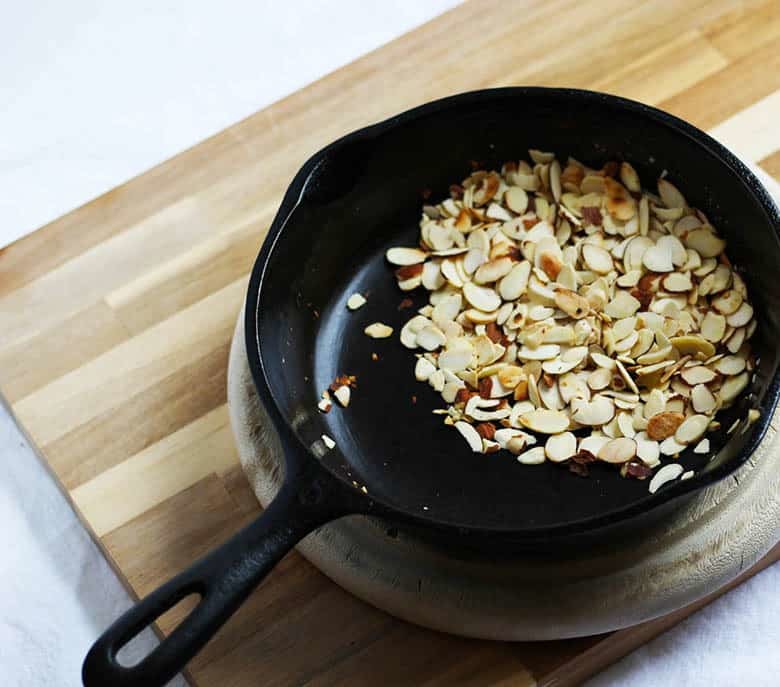 Sliced almonds in a cast iron skillet.