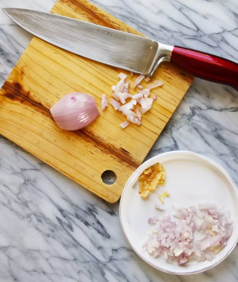 Shallots and garlic on a cutting board.