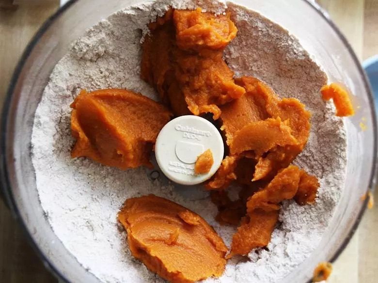 Food processor with flour and pumpkin.