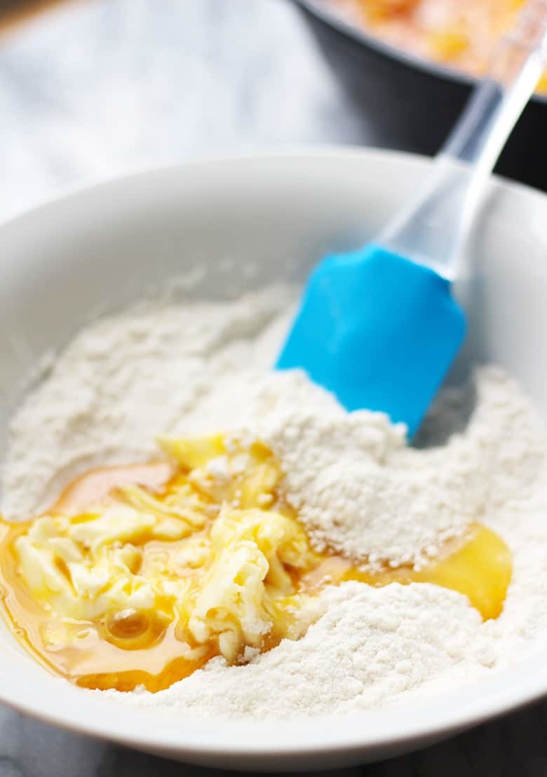 A mixing bowl with egg, butter, vanilla, flour.