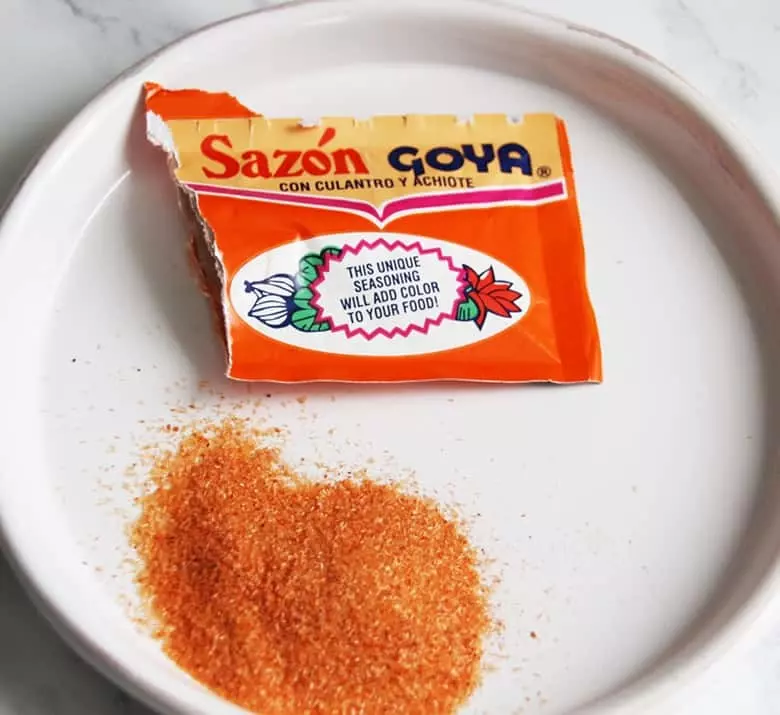 A packet of Sazon Goya con cilantro Y achiote on a white plate.