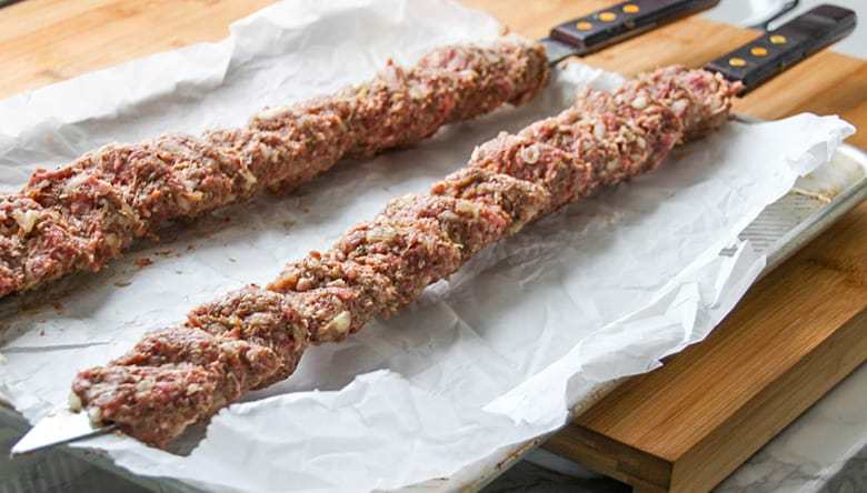 Raw ground meat on a skewer.