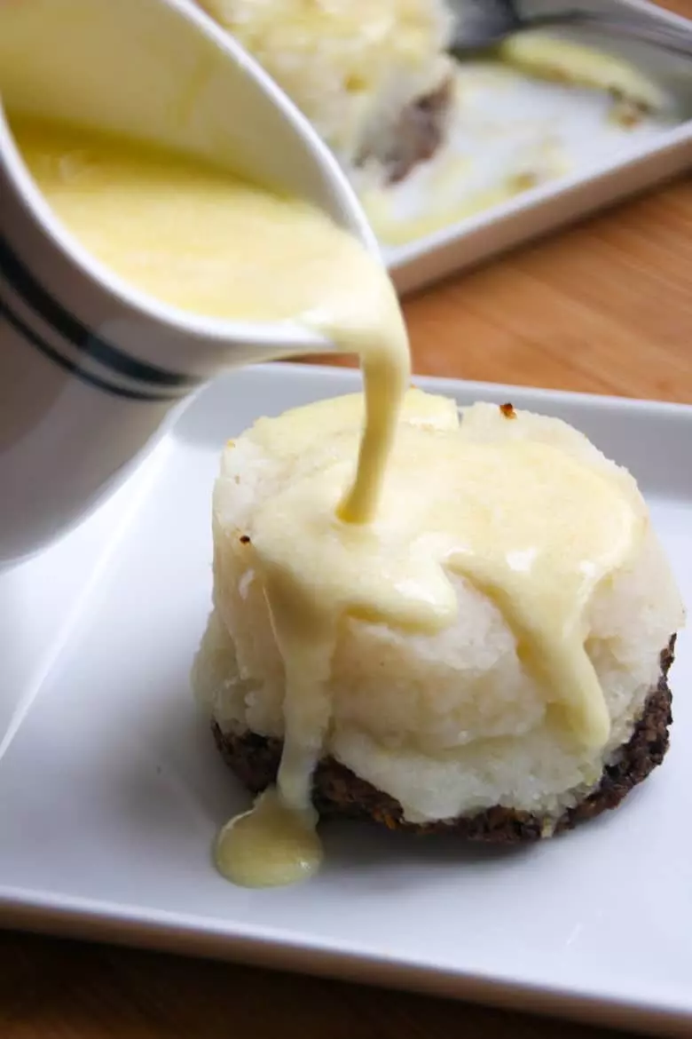 Whiskey butter sauce pouring over a haggis stack.