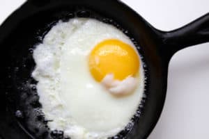 Sunny side up egg in a black skillet.