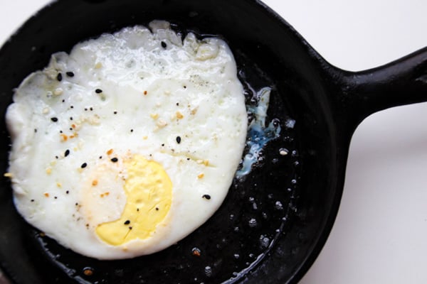 Over medium eggs in a black skillet.