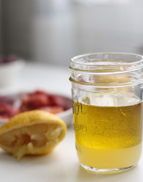 A mason jar with oil and lemon juice.