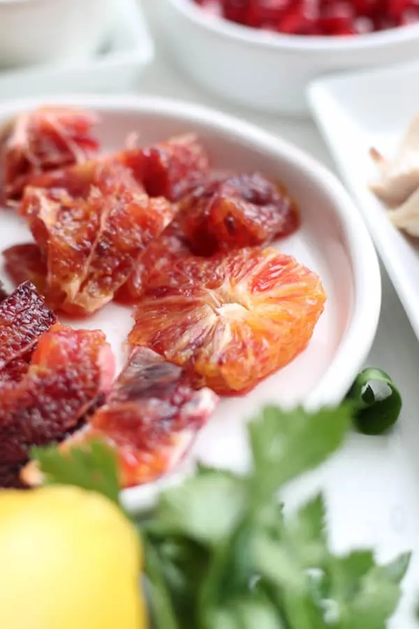 Blood oranges, sliced on a white plate.