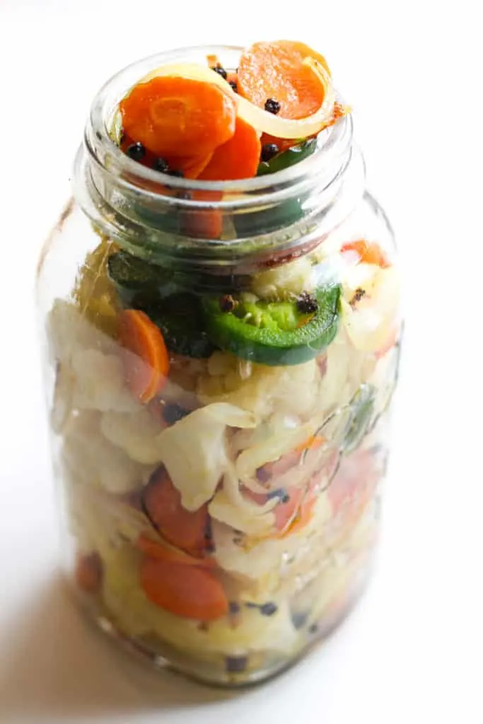 A jar full of vegetables.