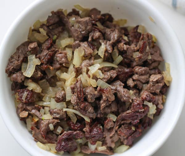 Carne asada, cooked with onions in a bowl.