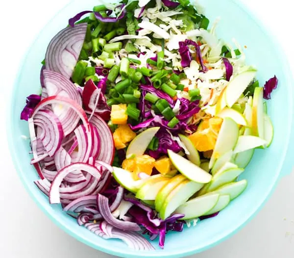A large mixing bowl of slaw ingredients.