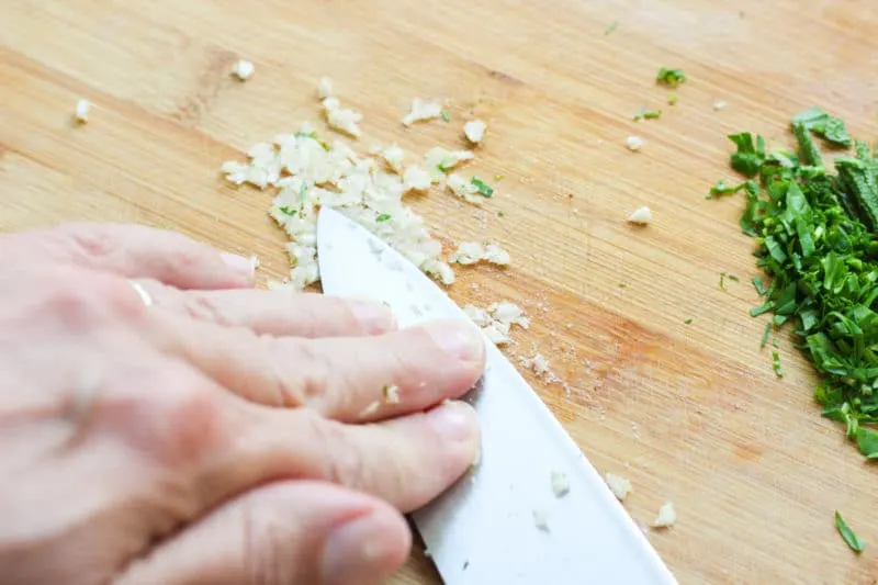 Mincing garlic with salt.