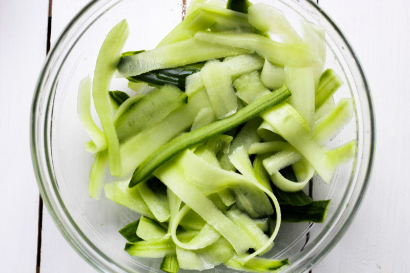 Cucumber slivers in a glass bowl.