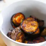 Roasted eggplant slices in a bowl.