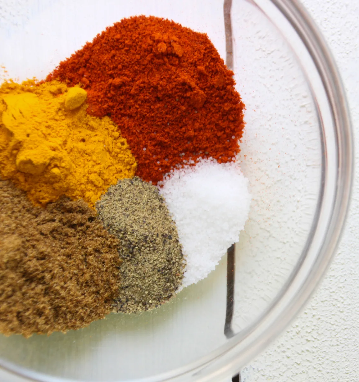 Spices for recipe in glass bowl.